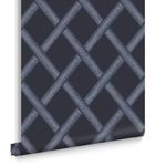 Rolled Greenskeeper Wallpaper showing edge curl and surface texture with geometric navy lattice detail