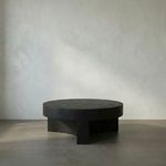 Steward Coffee Table in matte black industrial steel with circular top and curved, solid base