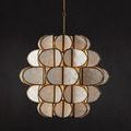 Chandelier illuminated against black wall emphasizing the shell panel details