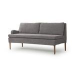 Three-quarter view showing left armrest and angled amber oak legs on Aurelia Dining Banquette