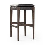 Aya Stool angled view focusing on the wood frame legs and connecting footrest bars