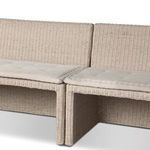 Oblique view of outdoor banquette showing seat cushions and rattan legs beneath