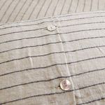 Detail of shell buttons close-up fastening the Blake duvet cover's opening on striped flax linen