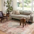 Heidi rug styled under sofa and chair in a bright living room with large window and plant