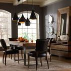 Dining room with Mimi Rider chairs arranged around rustic wood dining table under black pendant lights