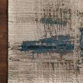 Close-up of rug corner on dark wood floor highlighting woven texture and bold blue motif