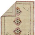 Rug with a folded corner revealing the reverse side and hand-knotted weave.