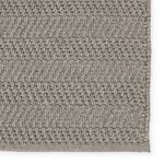 Detailed view of rug's striped texture focused on edge with tight woven border