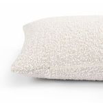 Side angle showing pillow's zipper crease and plush texture in off-white shades