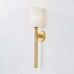 Lakeport Wall Sconce lit, showing soft glow through white cylindrical shade on a white wall