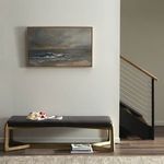 Same room view but from a slightly different angle, showing the painting over the bench near a stairway with wood and meta...