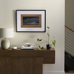 painting Backwash displayed on wall above console table with lamp, books, and plant in modern interior