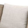 Close-up of beige textured cushion fabric against rattan cane side panel