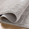 Rolled section of rug on wooden floor emphasizing fabric thickness and woven texture