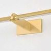 Close-up on brass knurled shade and rectangular wall mount with angled arm detail