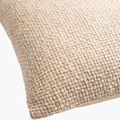 Close-up angle showing detailed woven cotton texture and fabric softness of beige accent pillow