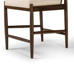 Detail of lower wood legs and footrest emphasizing warm wood finish and joinery