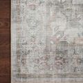 Close-up of rug corner on dark hardwood floor emphasizing texture and subtle blush accents