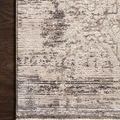 Close-up of rug corner showing subtle high-low texture and finely woven edges on dark wood floor