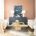 Light oak coffee table with white rattan inset in a beige living room styled between two cream armchairs