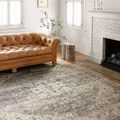 Hathaway rug styled in a bright living room with tan leather sofa and white brick fireplace