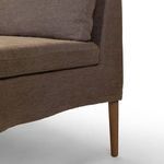Close-up of tapered oak leg with fabric skirt and linen upholstery detail