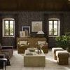 Rustic living room setting with painting hung above a fireplace surrounded by contemporary furnishings