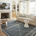 Fabian Denim rug styled in bright living room with fireplace, sofa, and white curtains
