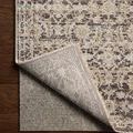 Rug corner partially folded back to reveal non-slip grey backing of midnight vintage style rug