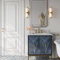 Pair of wall sconces flanking large beveled mirror above vanity in elegant bathroom