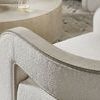 Close-up of textured upholstery and burlap trim on chair's rounded armrest