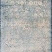 Rectangular traditional rug in light blue and ivory with distressed, ornate patterns and a dark blue border