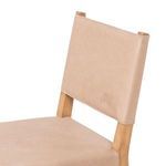 Close-up on top half of Villa Dining Chair focusing on leather back and wood frame