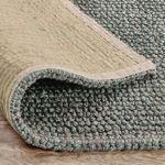 Backside of the rug folded to show woven jute texture and neutral backing fabric