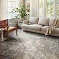 Austen Rug styled in a sunlit living room with beige sofa, leather chair, and large windows
