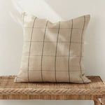 Louis Pillow styled upright on woven rattan bench with soft daylight on neutral wall