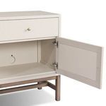 Open cabinet door revealing interior storage space and antique brass hinge detail
