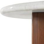 Oblique close-up of marble top edge rounded over crescent-shaped acacia leg