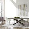 Dining table shown with white upholstered chairs and large abstract artwork in airy room