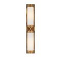 Front view of sconce illuminated, showing warm light glowing through opaque glass tubes