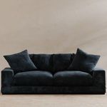 Plunge Sofa in dark navy corduroy fabric placed against a light beige wall on tan carpet