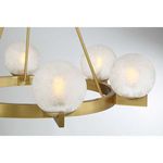 Close-up of frosted ice glass orb on warm brass fixture arm