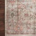 Close-up of corner of rug on dark wood floor highlighting pattern and muted colors