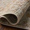 Rolled corner of the rug reveals the dense, low pile with textured vintage-style pattern in ivory and ochre
