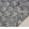 Corner of Beckett rug folded to reveal non-slip textured backing beneath gray chevron pattern