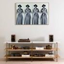 Ronald Reagan cowboy photo hung on wall above mid-century modern console with speakers and decor