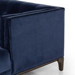 Side perspective of navy velvet sofa showing arm height and wooden leg finish