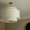 Side angle of Sawyer pendant mounted on ceiling with beige walls and decorative basket art
