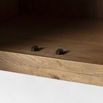 Inside view of cabinet bottom with metal catches on wood shelf surface.