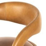 Close-up showing rounded contour and stitching detail of backrest arm on leather stool